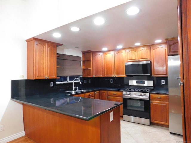 kitchen featuring sink, appliances with stainless steel finishes, tasteful backsplash, light tile patterned flooring, and kitchen peninsula