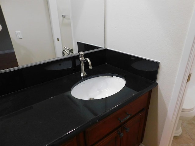 bathroom with tile patterned flooring, vanity, and toilet