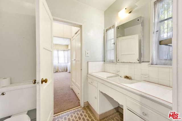 bathroom featuring decorative backsplash, toilet, and vanity