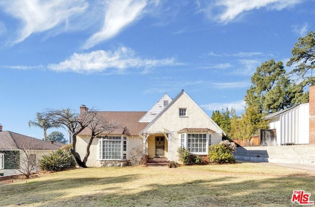 tudor-style house with a front lawn