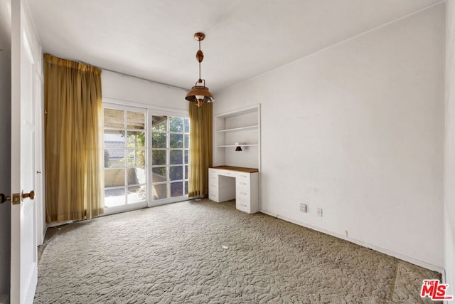 spare room with built in shelves and carpet floors