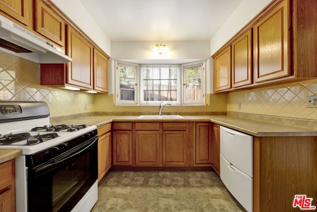 kitchen featuring gas stove, white dishwasher, and sink