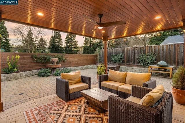 patio terrace at dusk with outdoor lounge area and ceiling fan