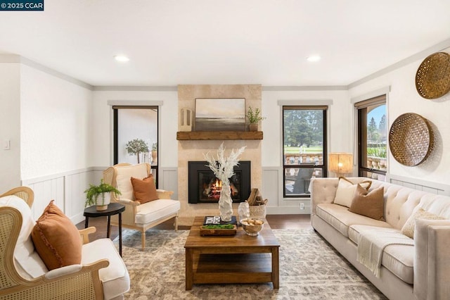 living room with crown molding, a high end fireplace, and wood-type flooring