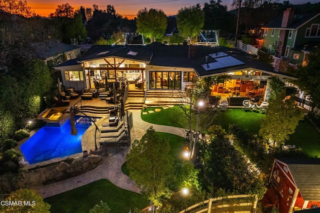 back house at dusk featuring outdoor lounge area and a patio