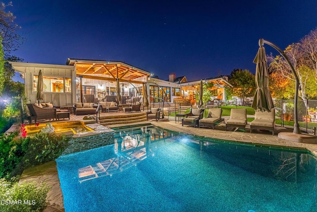 pool at twilight featuring an outdoor hangout area, an in ground hot tub, and a patio