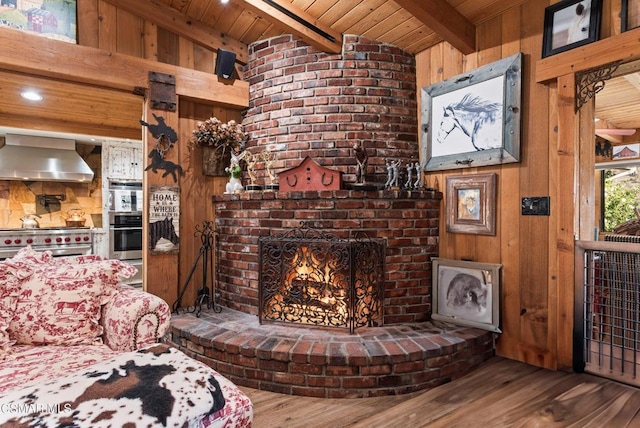 living room featuring wooden walls, lofted ceiling with beams, hardwood / wood-style flooring, wooden ceiling, and a fireplace