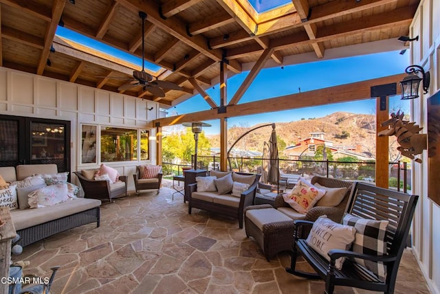 view of patio featuring an outdoor living space, ceiling fan, and a mountain view