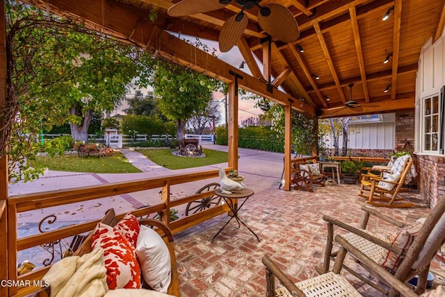 patio terrace at dusk with a yard and ceiling fan