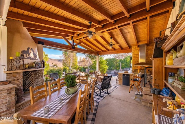 view of patio / terrace featuring exterior bar, ceiling fan, a mountain view, and an outdoor kitchen