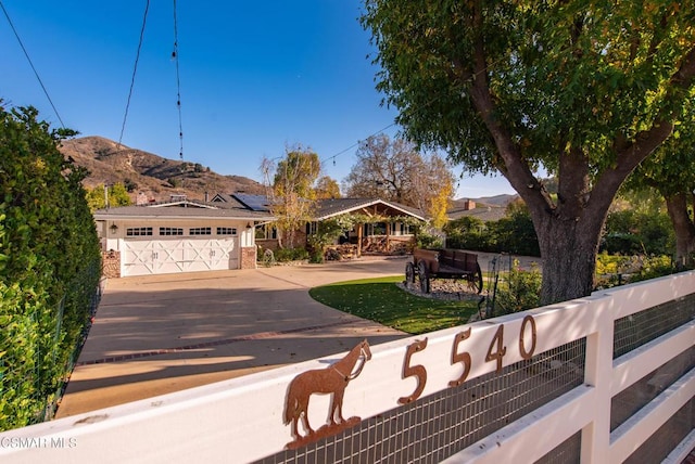 view of front of home with solar panels, a garage, and a mountain view