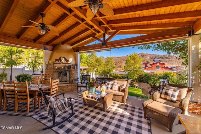 view of patio with a gazebo, a mountain view, ceiling fan, and an outdoor living space with a fireplace