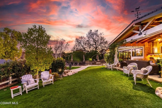 yard at dusk featuring a patio area