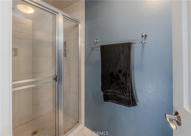 bathroom featuring a shower with shower door