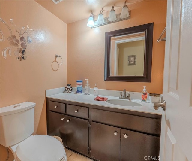 bathroom featuring tile patterned floors, vanity, and toilet