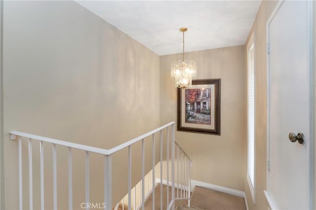 staircase with a chandelier