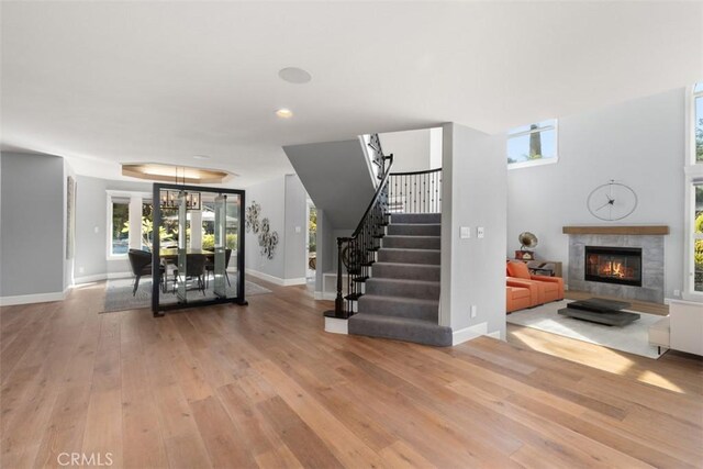 living room with wood-type flooring and a tiled fireplace