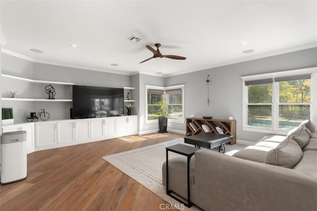 living room with hardwood / wood-style floors, crown molding, a healthy amount of sunlight, and ceiling fan