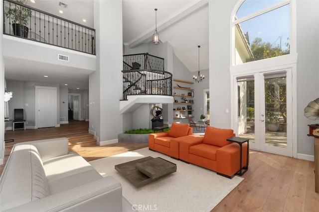 living room featuring an inviting chandelier, light wood-type flooring, and a high ceiling