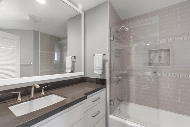 bathroom featuring tiled shower / bath combo and vanity