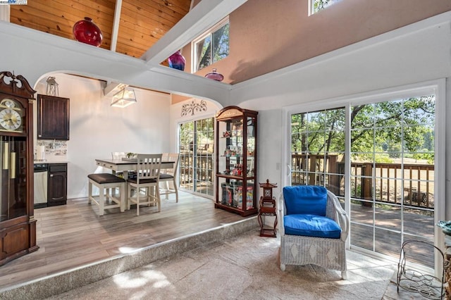 dining space with a towering ceiling, beam ceiling, and wood ceiling