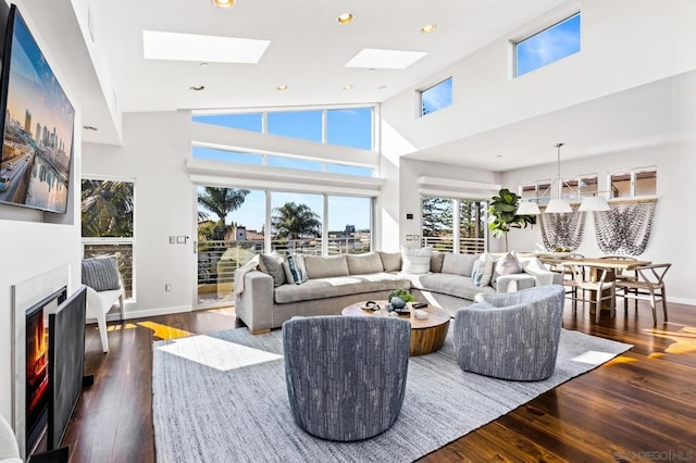 living room with a skylight and dark hardwood / wood-style flooring