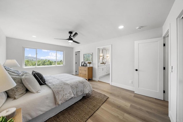 bedroom with ceiling fan, light hardwood / wood-style floors, and connected bathroom