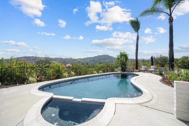 view of swimming pool with a mountain view and a patio area