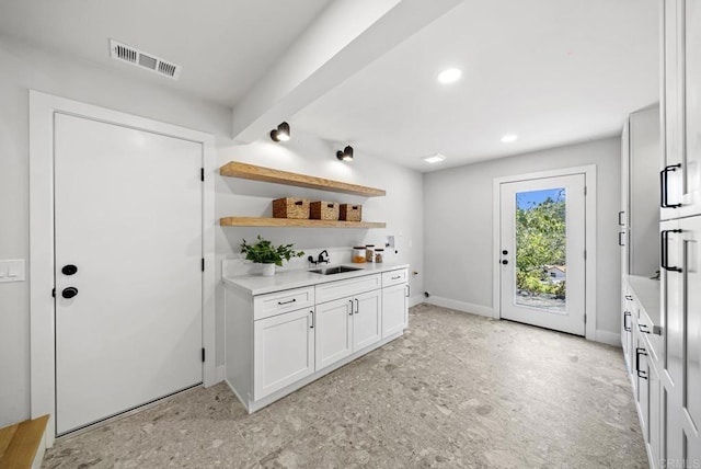 bar with sink and white cabinetry