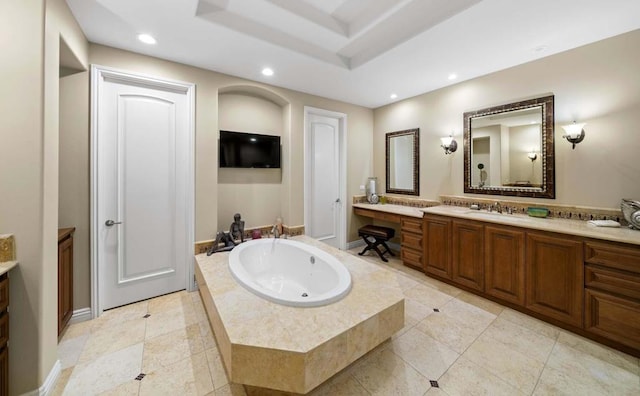 bathroom with tile patterned floors, a tray ceiling, vanity, and a relaxing tiled tub