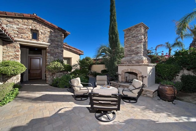 view of patio / terrace featuring an outdoor stone fireplace