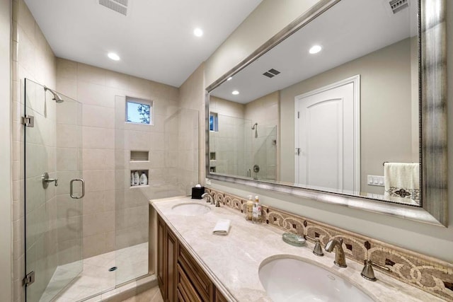 bathroom with vanity and a shower with door