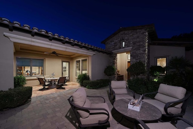 patio at night featuring ceiling fan