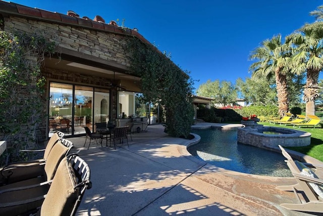 view of home's community with a pool with hot tub and a patio