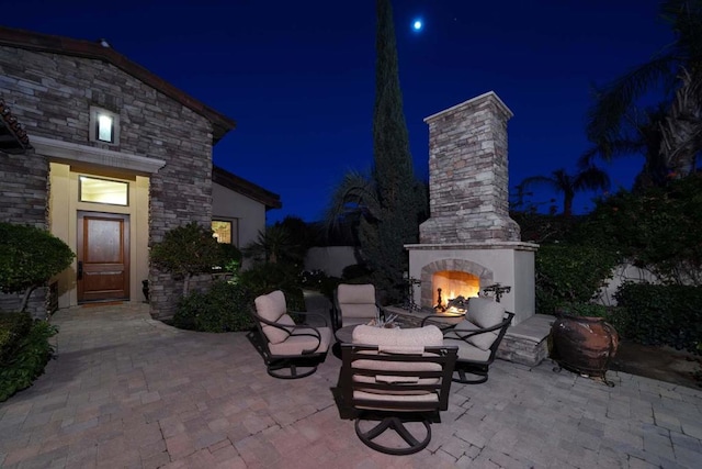 patio at twilight with an outdoor stone fireplace