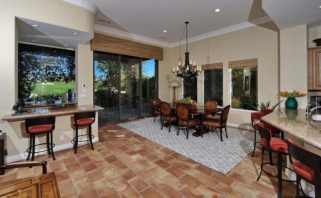 dining space with ornamental molding and an inviting chandelier