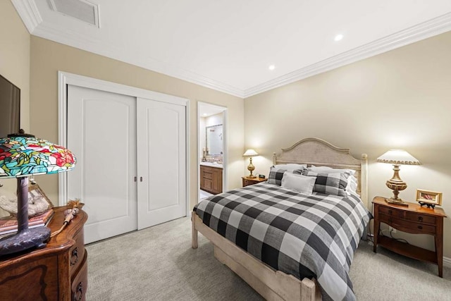 bedroom featuring ensuite bath, light carpet, a closet, and ornamental molding