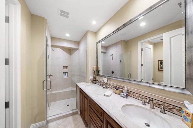 bathroom featuring tile patterned floors, vanity, and a shower with door