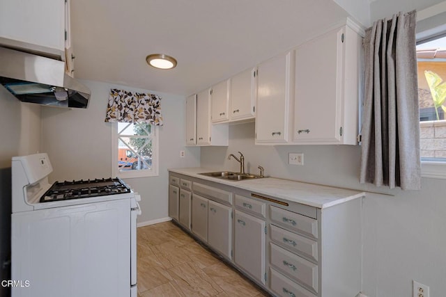 kitchen with white cabinetry, gas range gas stove, and sink