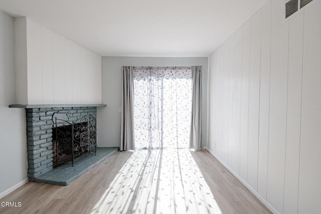 unfurnished living room featuring light wood-type flooring and a fireplace