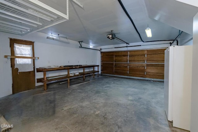 garage featuring white refrigerator and a garage door opener