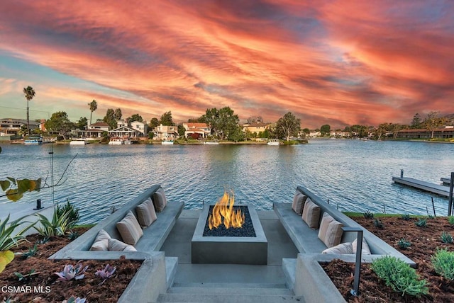 dock area with a fire pit and a water view