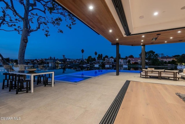 view of swimming pool with a patio area and a water view