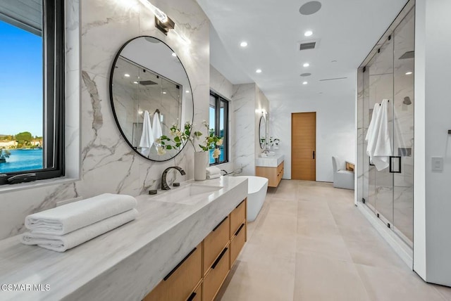 bathroom featuring vanity, an enclosed shower, tile walls, and a wealth of natural light