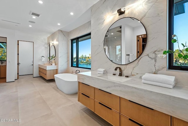 bathroom featuring vanity, tile walls, and a washtub