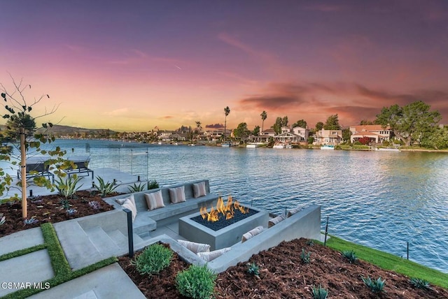 dock area with a water view and an outdoor fire pit