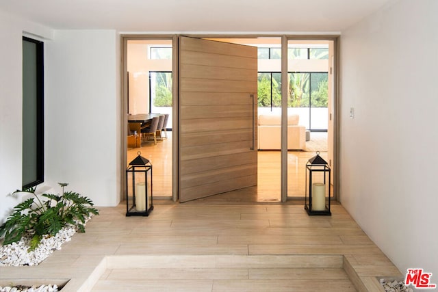 doorway to outside with expansive windows and light wood-type flooring