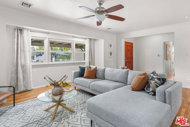 living room featuring crown molding, ceiling fan, and light hardwood / wood-style floors