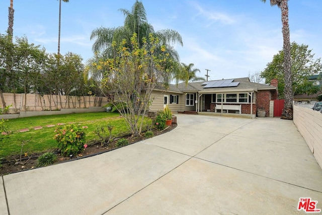 view of front of house with a front yard and solar panels