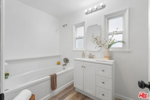 bathroom with vanity, a bathtub, and hardwood / wood-style flooring